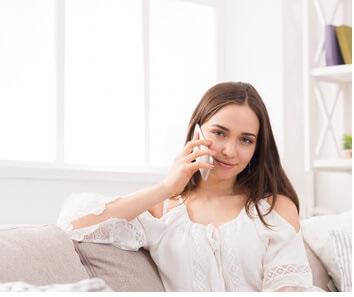 Woman on couch chatting on phone